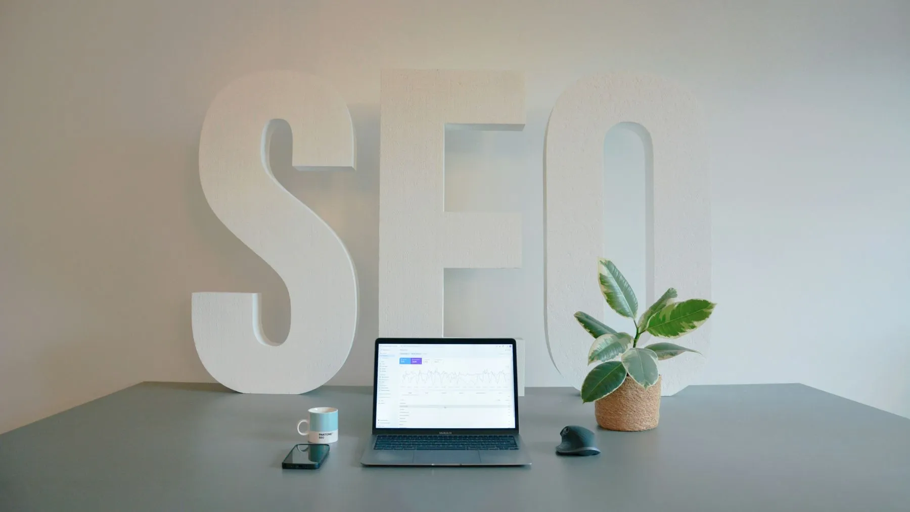 SEO 2025 hero laptop på bord med ordet SEO bakom